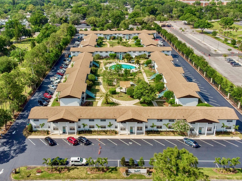 Aerial View of The Fisher Apartment buildings with ample green space, resident parking, and a community pool.